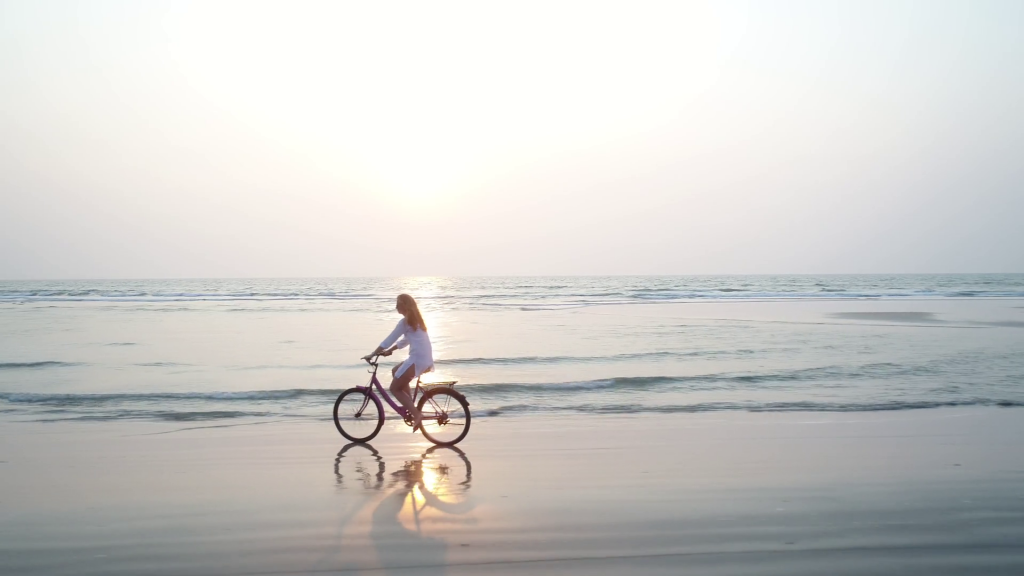 woman riding bicycle along the beach