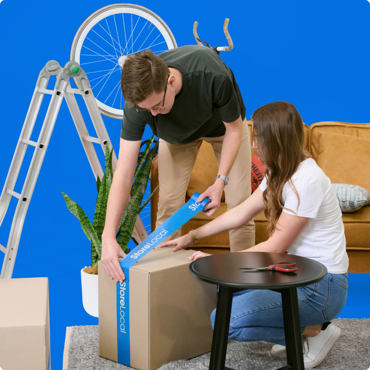 A man and woman unpacking boxes on a blue background.