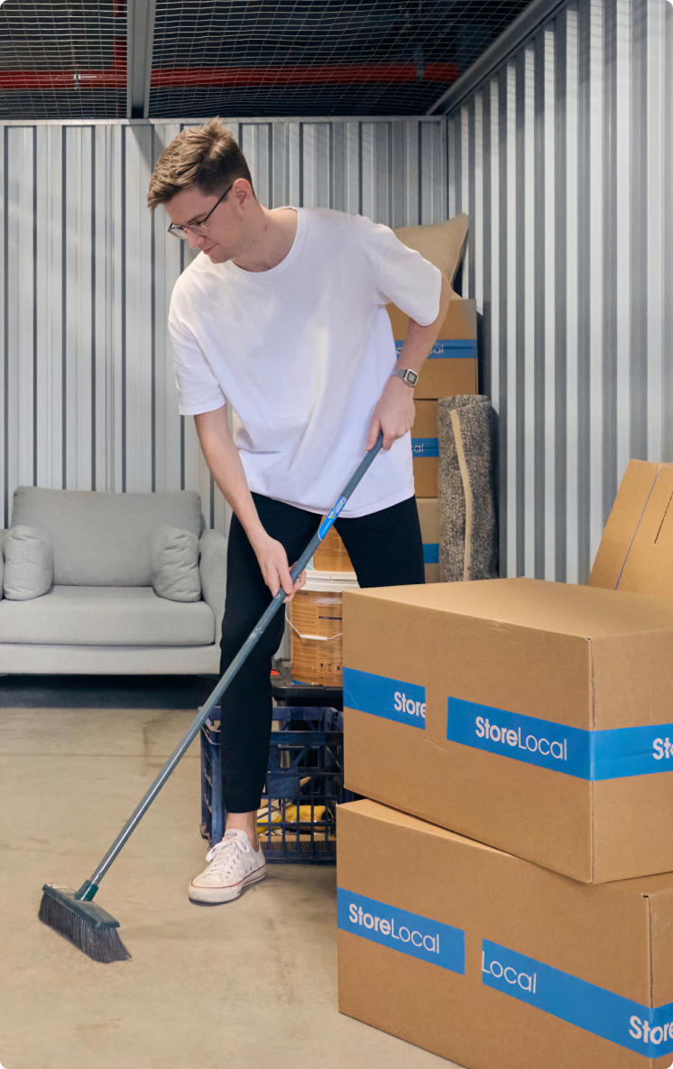 A man cleaning boxes in a storage unit.