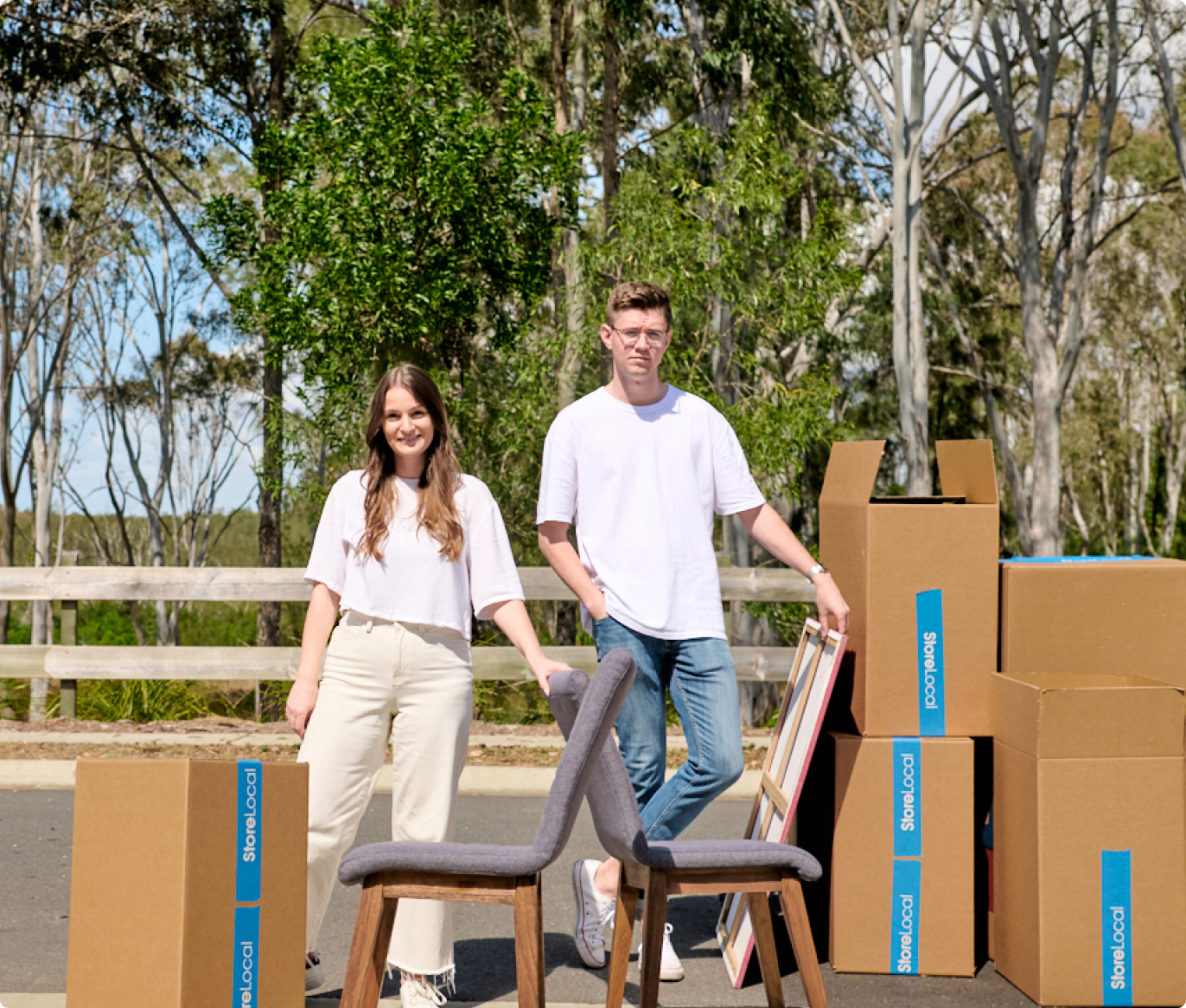 Two people standing next to boxes in a parking lot.