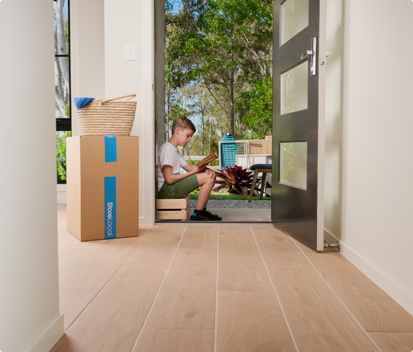 A boy sitting on the floor in front of a door.