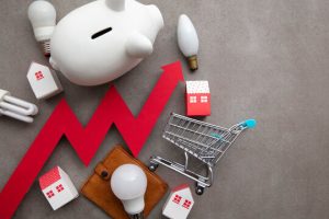 A piggy bank and shopping cart filled with light bulbs, sitting on a concrete floor.