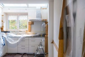 white kitchen under renovation with lots of light coming through window