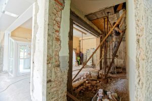 construction worker climbing ladder in house that's in renovation mode